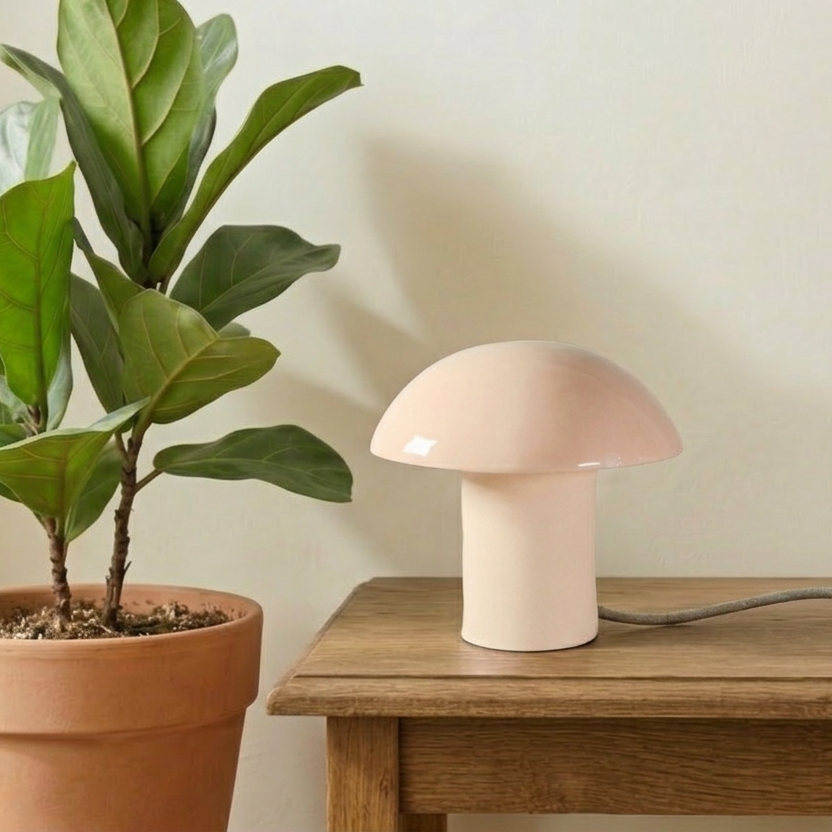 Lampada da tavolo Kalakera in ceramica artigianale color rosa. Caratterizzata da un design a fungo con base materica e paralume smaltato lucido, perfetta per un arredamento minimalista e organico.