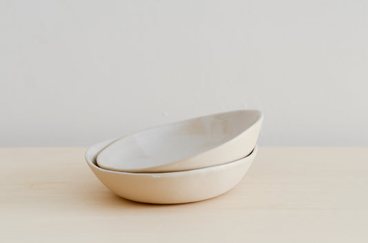 due piatti fondi fatti a mano in ceramica e di colore beige all'esterno e bianco all'interno